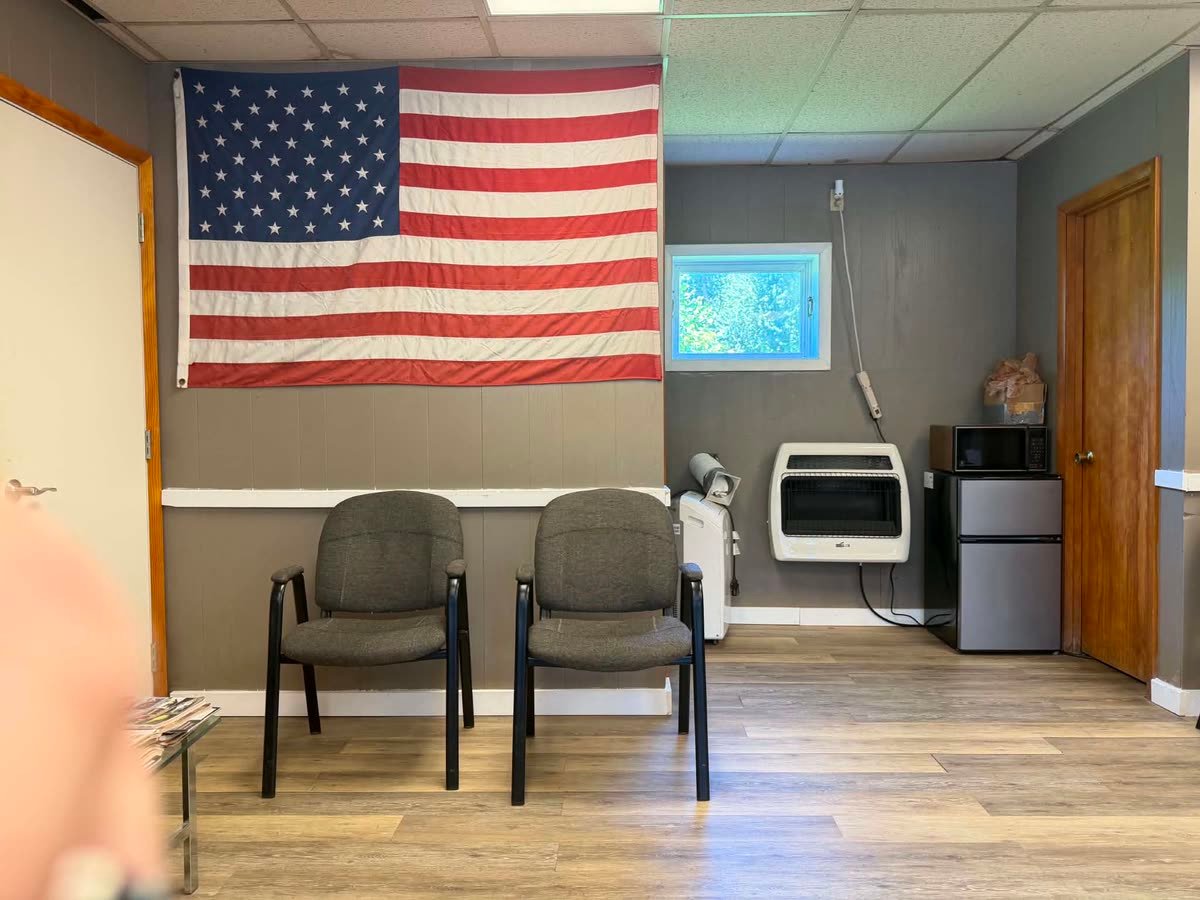 Waiting chairs beneath a large American flag.